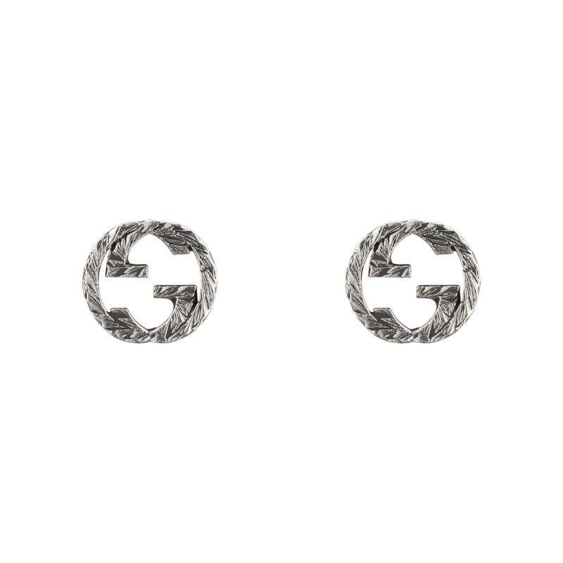 A pair of Gucci Interlocking G Sterling Silver Stud Earrings from GUCCI Fine Jewellery, these silver-toned circular studs are crafted from 925 sterling silver and feature a textured finish with a unique cut-out design reminiscent of interlocking letters.