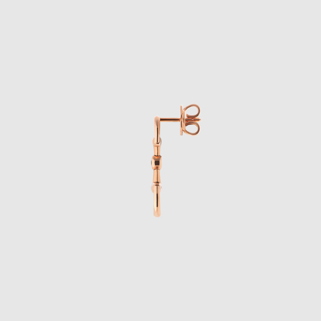 A single Gucci Horsebit 18K rose gold diamond drop earring from GUCCI Fine Jewellery, featuring a slender vertical design and butterfly back, displayed against a plain light gray background.