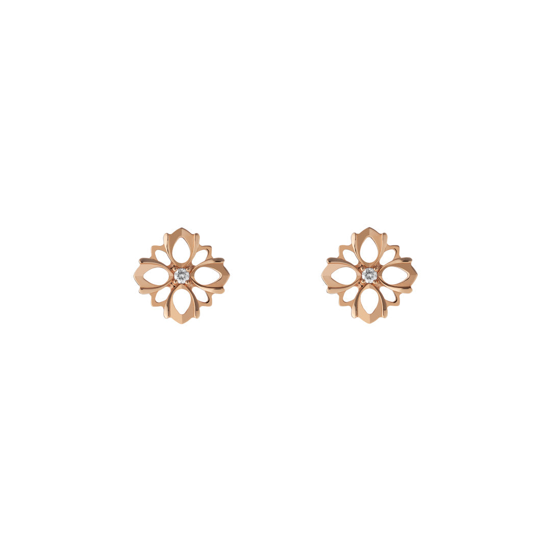 Introducing the Gucci Flora line by GUCCI Fine Jewellery: 18K rose gold stud earrings with a floral shape, intricate cutout designs, and a small central gemstone. These elegant diamond earrings exude timeless beauty and sophistication against a plain white background.