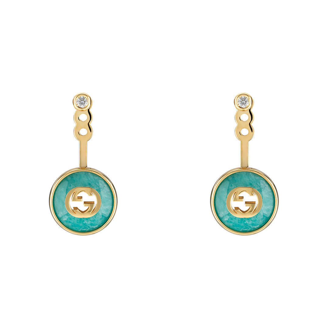 The Gucci Interlocking 18K Yellow Gold Drop Earrings by GUCCI Fine Jewellery feature turquoise circular pendants with cut-out designs. Connected by a short gold bar, they include a diamond-like stud and amazonite stone, meeting Responsible Jewelry Council standards.