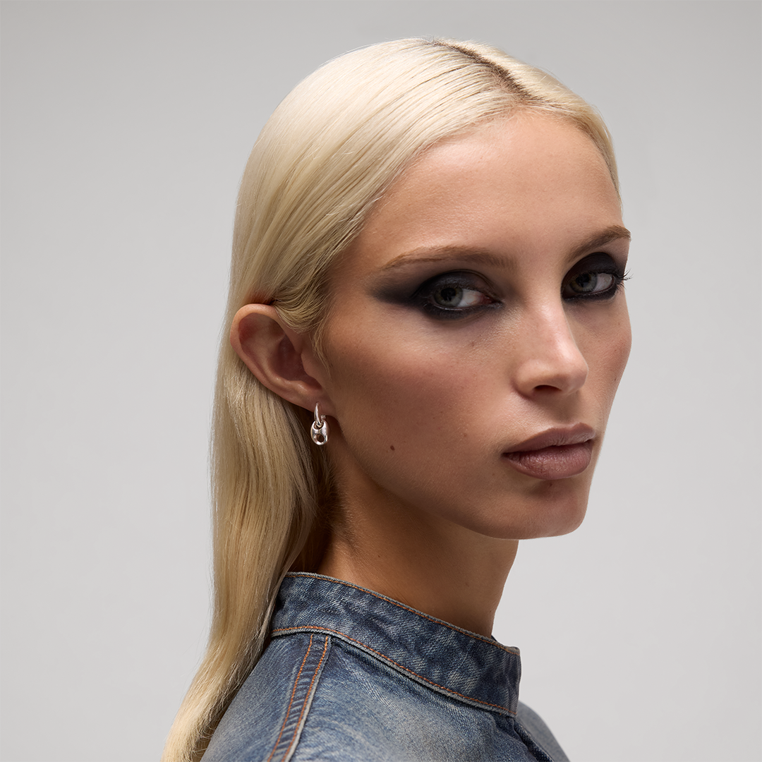 A person wearing a sterling silver Gucci Marina Sterling Silver Chain Pendant Earring.