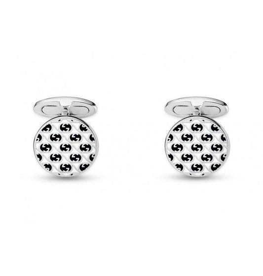 A pair of Gucci Interlocking G cufflinks from GUCCI Fine Jewellery, crafted in sterling silver, featuring a round black and white interlocking geometric pattern. The sleek white background elegantly accentuates these sophisticated accessories.