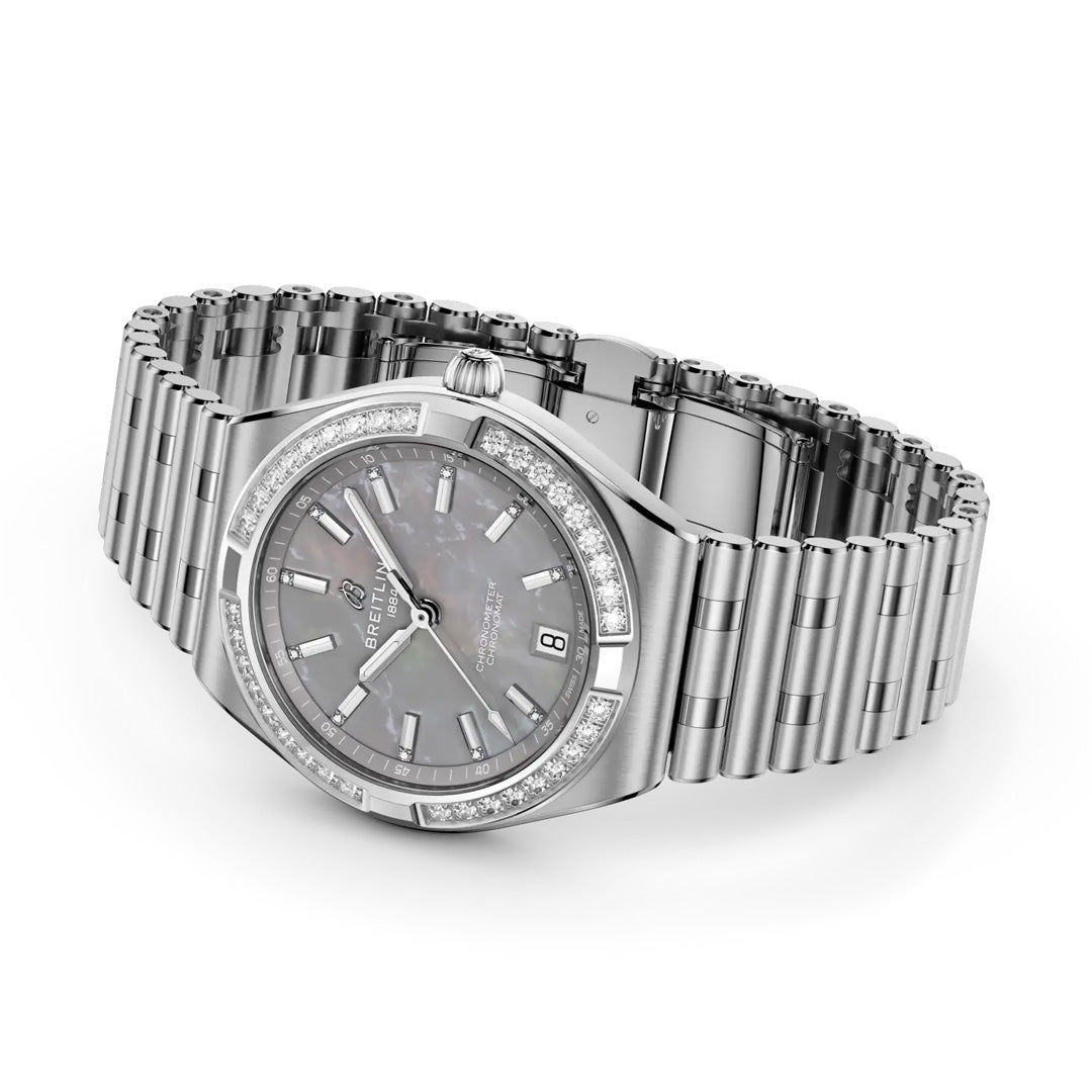 The BREITLING Chronomat Automatic 36 by Breitling, a COSC-certified silver luxury watch with metal bracelet, mother-of-pearl dial, diamond hour markers, and diamond-set bezel, is shown at an angle on a white background.