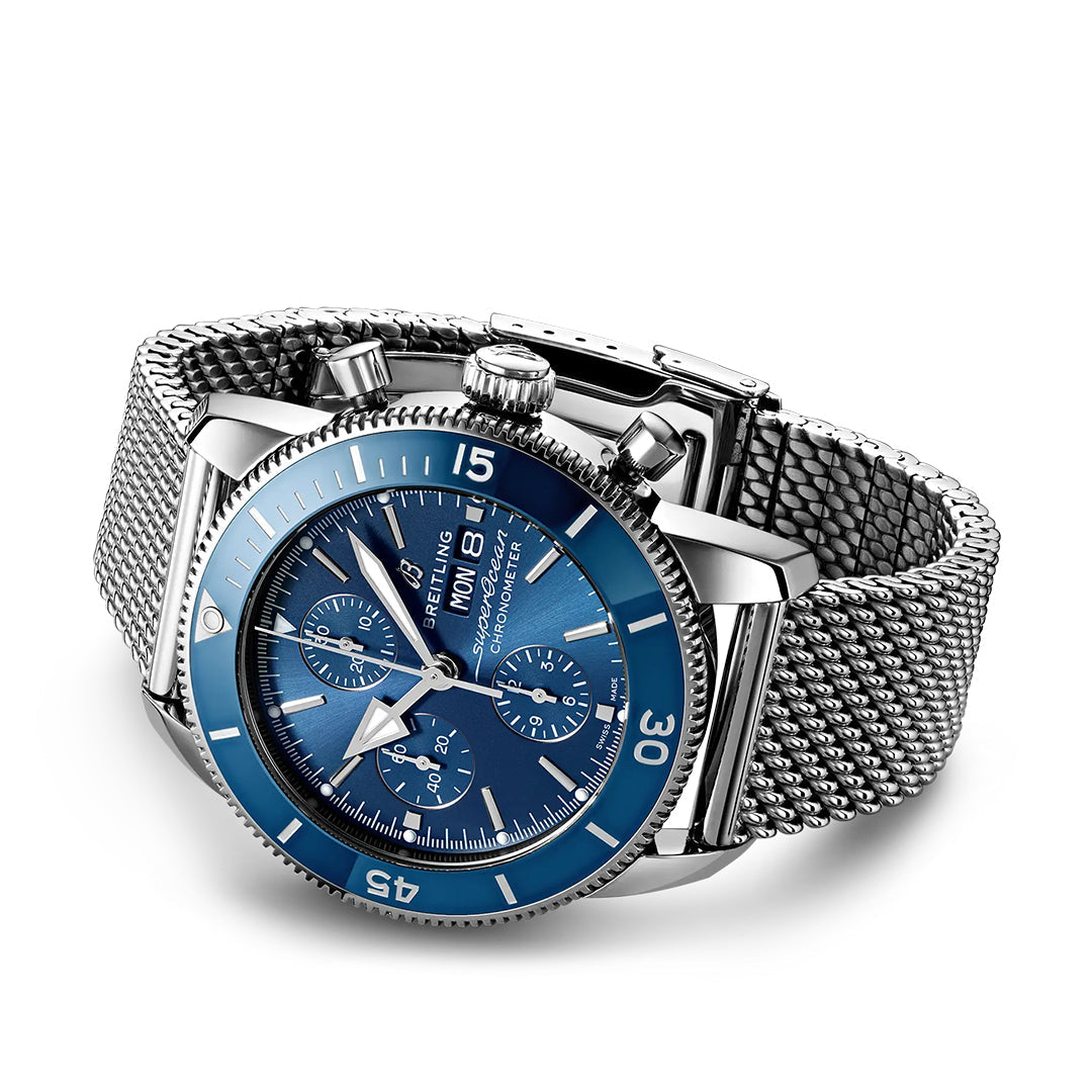 The BREITLING Superocean Heritage Chronograph 44 is a luxury diver's watch featuring a blue face, chronograph functions, and robust Breitling Caliber 13. It has a stainless steel mesh band, rotating bezel, and three sub-dials for day display, combining style with precision.