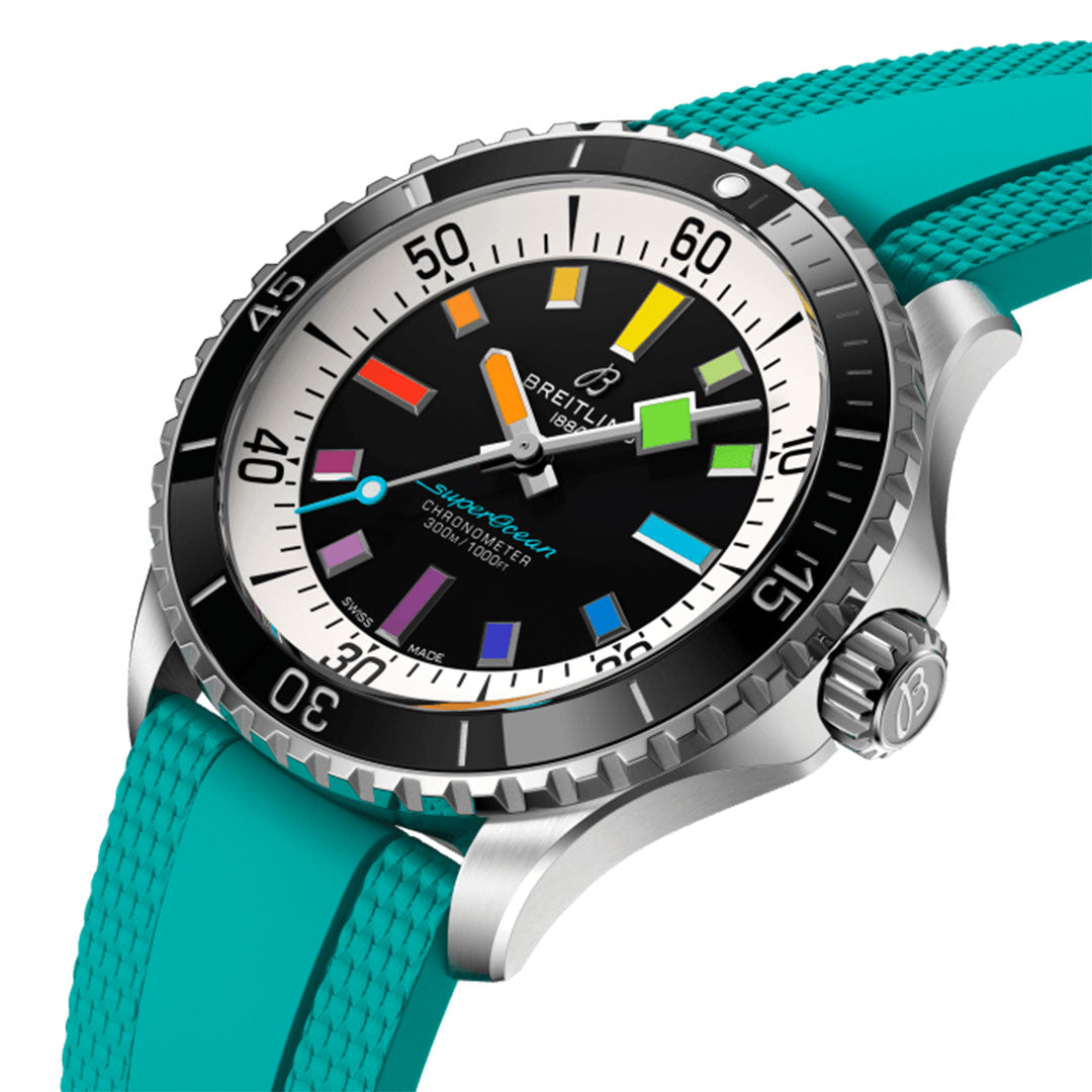 The BREITLING Superocean Automatic 42 by Breitling is a colorful wristwatch with a black dial showcasing luminescent indexes in blue, red, green, orange, and yellow. It features a scratch-proof ceramic bezel and comes with a vibrant teal strap that enhances its allure.