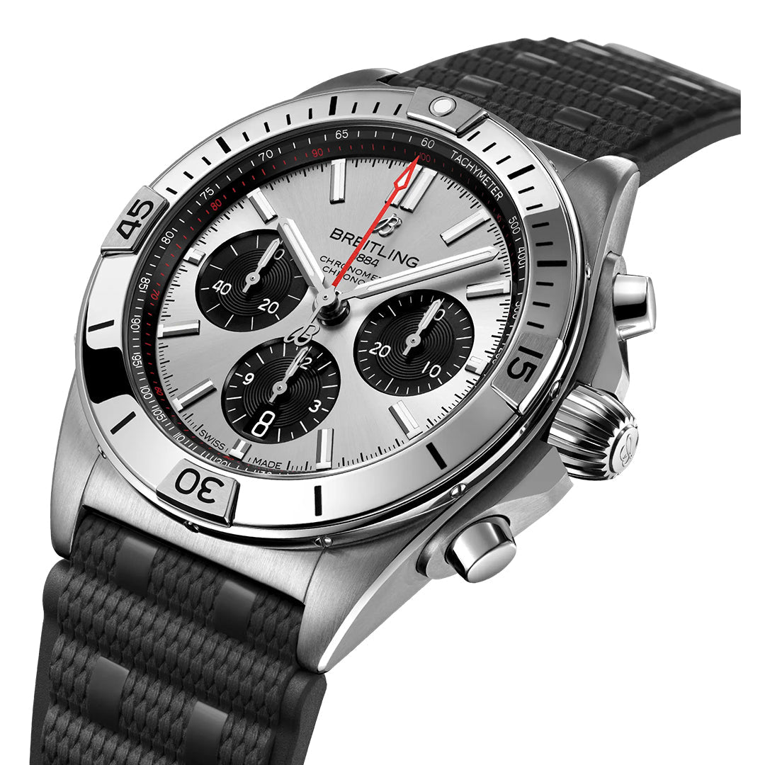 The BREITLING Chronomat B01 42, crafted by Breitling, is a silver and black chronograph watch with a stainless steel case featuring three subdials, date display, luminescent hands, tachymeter-marked bezel, and comes with a textured black leather or rubber strap.