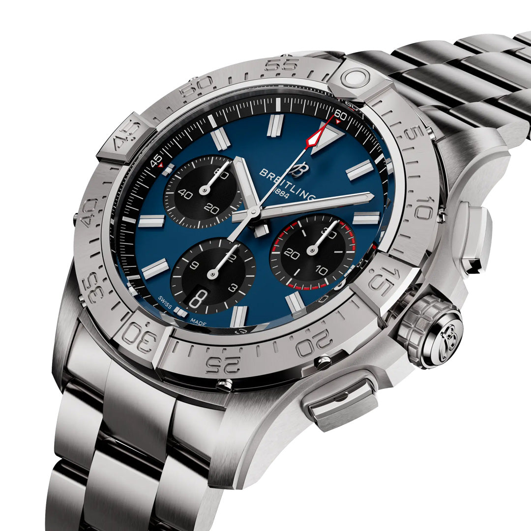 The BREITLING Avenger B01 Chronograph 42 features a blue dial with three subdials, an aviation-style tachymeter bezel, and luminous hands on a polished steel bracelet. The Breitling name is prominently displayed on the stainless steel watch.