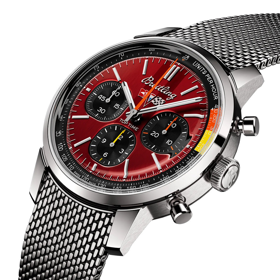 The BREITLING Top Time B01 Chevrolet Corvette showcases a red dial, silver case, and metal mesh strap. It features three sub-dials, luminescent hands, a tachymeter bezel scale, and the brand name elegantly below 12 o'clock for refined sophistication.