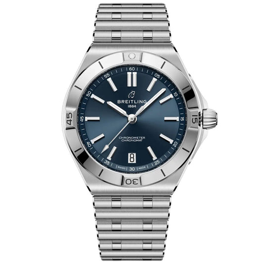 The BREITLING Chronomat B31 40 is a stainless steel watch with a blue dial, silver markers, date window at 6 o’clock, COSC-certified chronograph, Breitling logo, and signature Rouleaux bracelet.