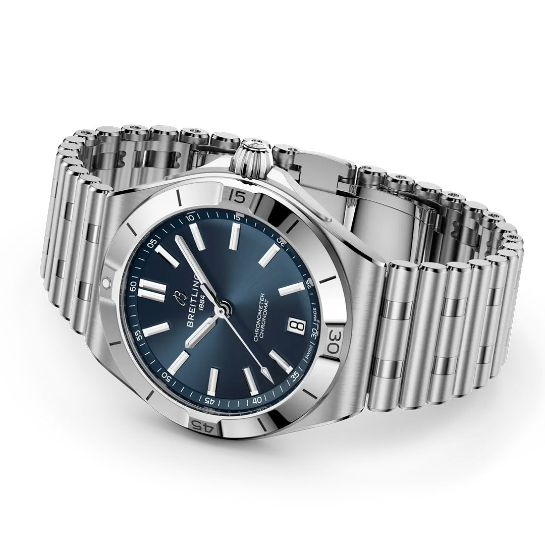 The BREITLING Chronomat B31 40, a stainless steel wristwatch by Breitling with a blue dial, silver hour markers, 6 o’clock date display, and Rouleaux bracelet is shown angled on a white background.