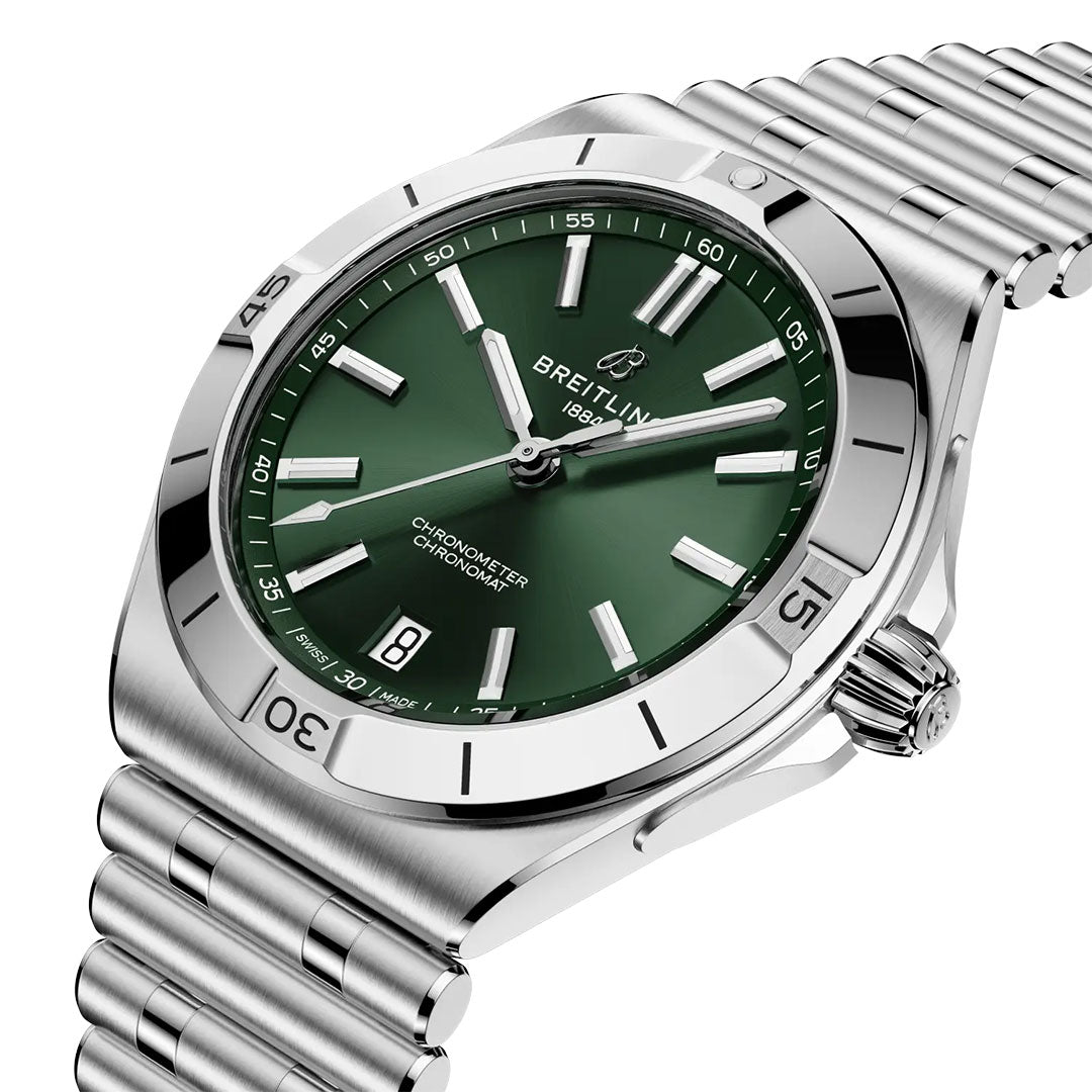 The BREITLING Chronomat B31 40 is a luxury sports watch with a silver finish, green dial, silver hour markers, COSC-certified precision, date display at 6 o'clock, and a stainless steel bracelet and bezel.