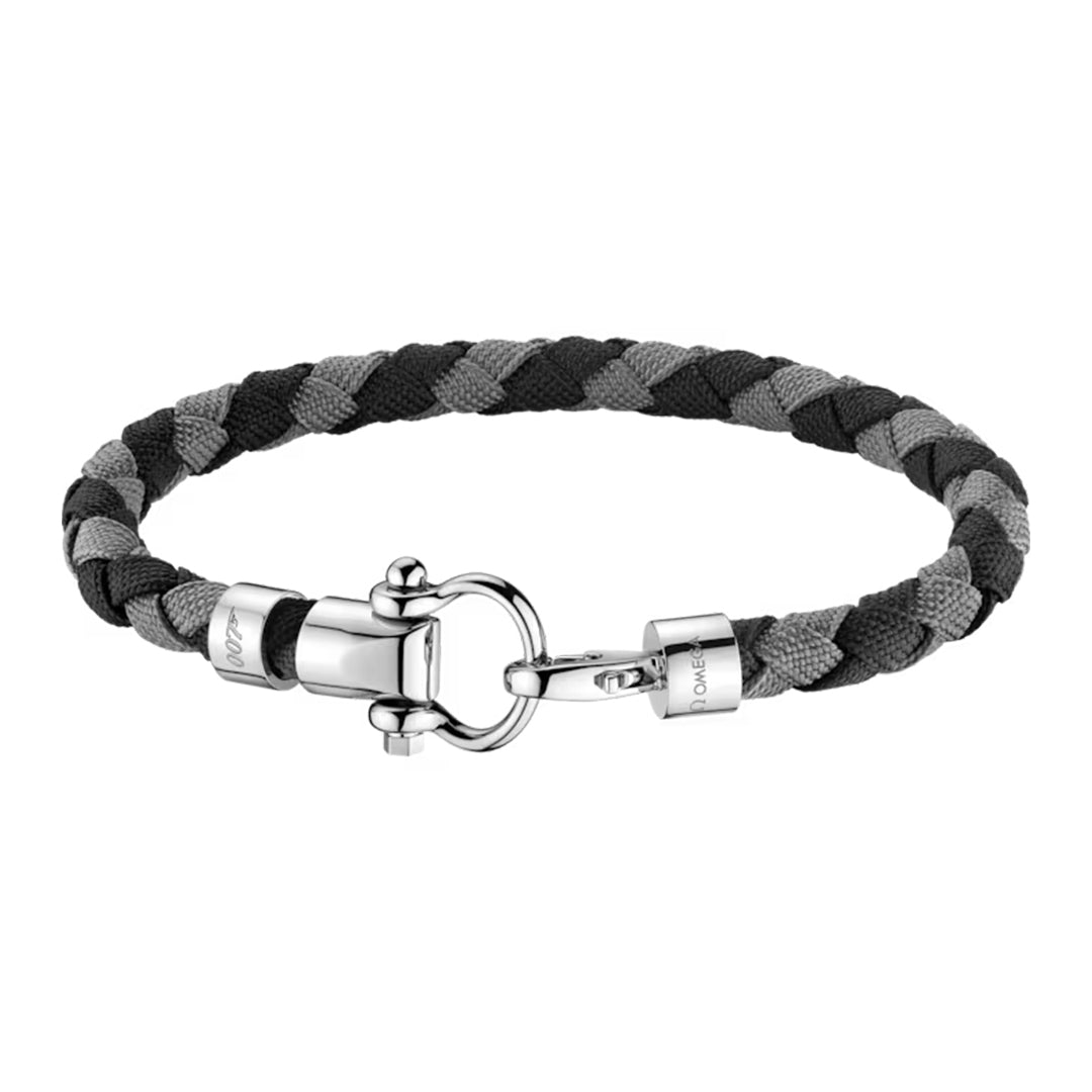 The OMEGA Aqua Sailing Nylon Bracelet by OMEGA features a braided design with black and gray strands, a sleek stainless steel clasp, and detailed engravings. Combining fabric and metal elements, it offers a modern, sophisticated touch.