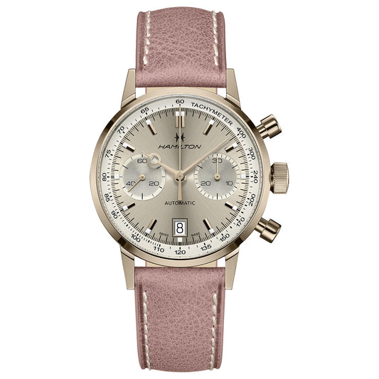 The Hamilton American Classic Intra-Matic Auto Chrono 40mm Watch, crafted by Hamilton Watch, showcases an elegant design featuring a sizable silver dial with three sub-dials and a date display at the 6 o'clock position. It is equipped with an automatic chronograph movement and includes a tachymeter scale along the perimeter, enhanced by a pink leather strap with white stitching.