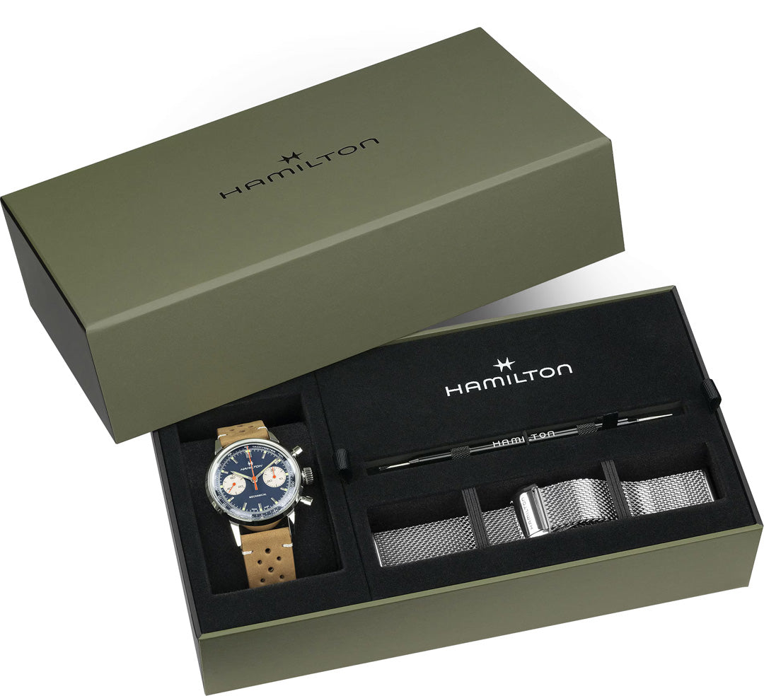 An olive green Hamilton Watch box holds a Hamilton American Classic Intra-Matic Mechanical Chronograph H 40mm with tan leather strap, blue dial, an extra silver mesh strap, and a black strap-changing tool, each in its own compartment.