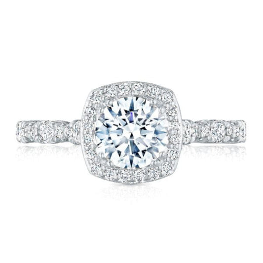 The Tacori Petite Crescent 18K White Gold Cushion Semi Mount with Diamond Band and Halo Engagement Ring showcases a stunning central round diamond surrounded by a halo of smaller French pavé diamonds. The band is embellished with additional small diamonds, enhancing its sparkle and demonstrating the craftsmanship of Tacori gemologists.