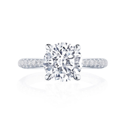 A stunning engagement ring from the Tacori Founder's Collection features a large round-brilliant diamond centerpiece, set on a lustrous platinum band adorned with smaller diamonds. The Signature Crescent design of the Tacori RoyalT Solitaire Semi Mount is elegantly showcased against a white background.