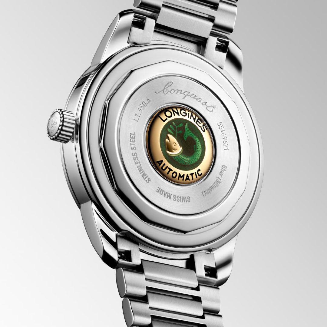 A close-up of the Longines Conquest Heritage Automatic 40mm Watch displays its stainless steel case, silver bracelet, and a circular window featuring a green seahorse emblem with "LONGINES AUTOMATIC," highlighting its vintage style.