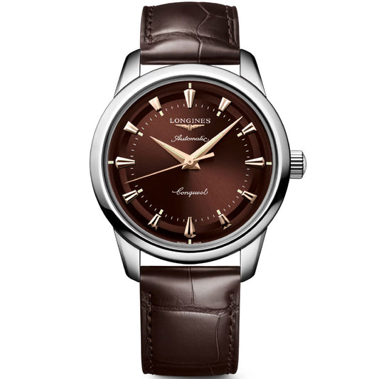 The Longines Conquest Heritage Automatic 40mm Watch features a brown dial, silver case, gold markers and hands, and a brown leather strap. "Longines," "Automatic," and "Conquest" are displayed on the dial, highlighting its vintage style.