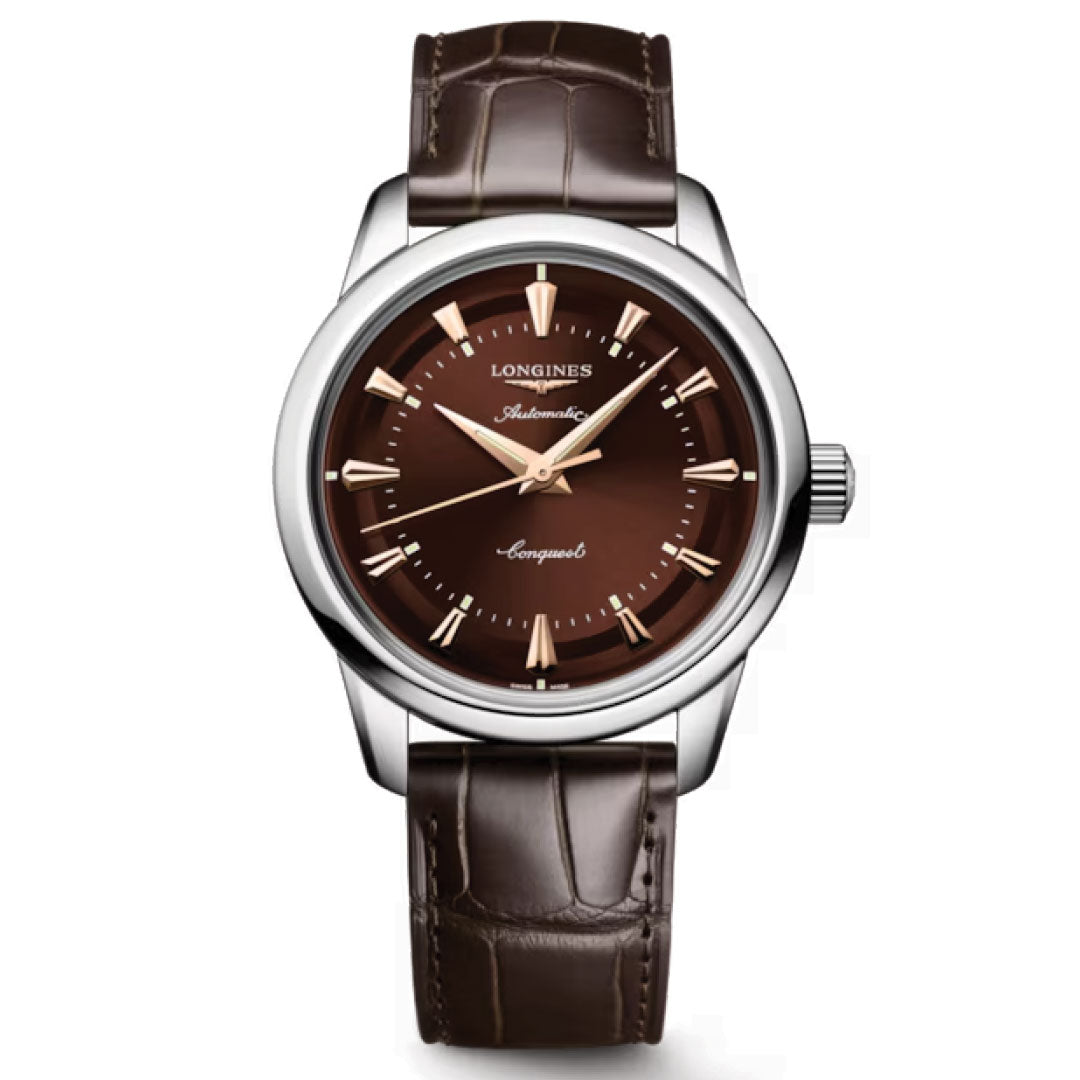 The Longines Conquest Heritage Automatic 38mm Watch pairs vintage style with modern craftsmanship, featuring a brown leather strap, brown dial, gold markers and hands, a silver-tone case, and "Longines Automatic Conquest Heritage" on the face.