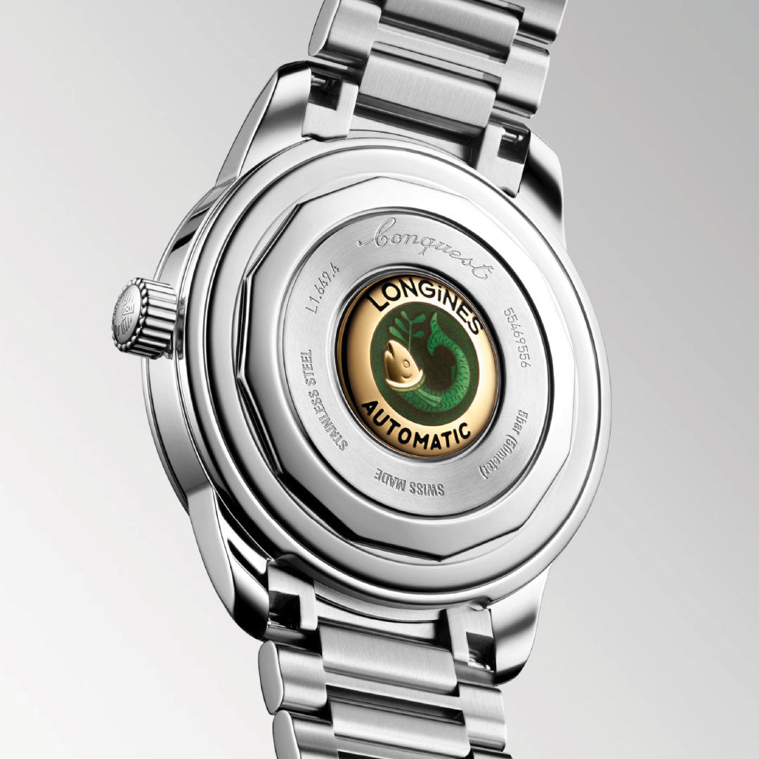 Close-up of the Longines Conquest Heritage Automatic 38mm watch’s caseback, featuring a steel case, engraved accents, and a gold medallion with a green seahorse, paired with a silver metal bracelet.