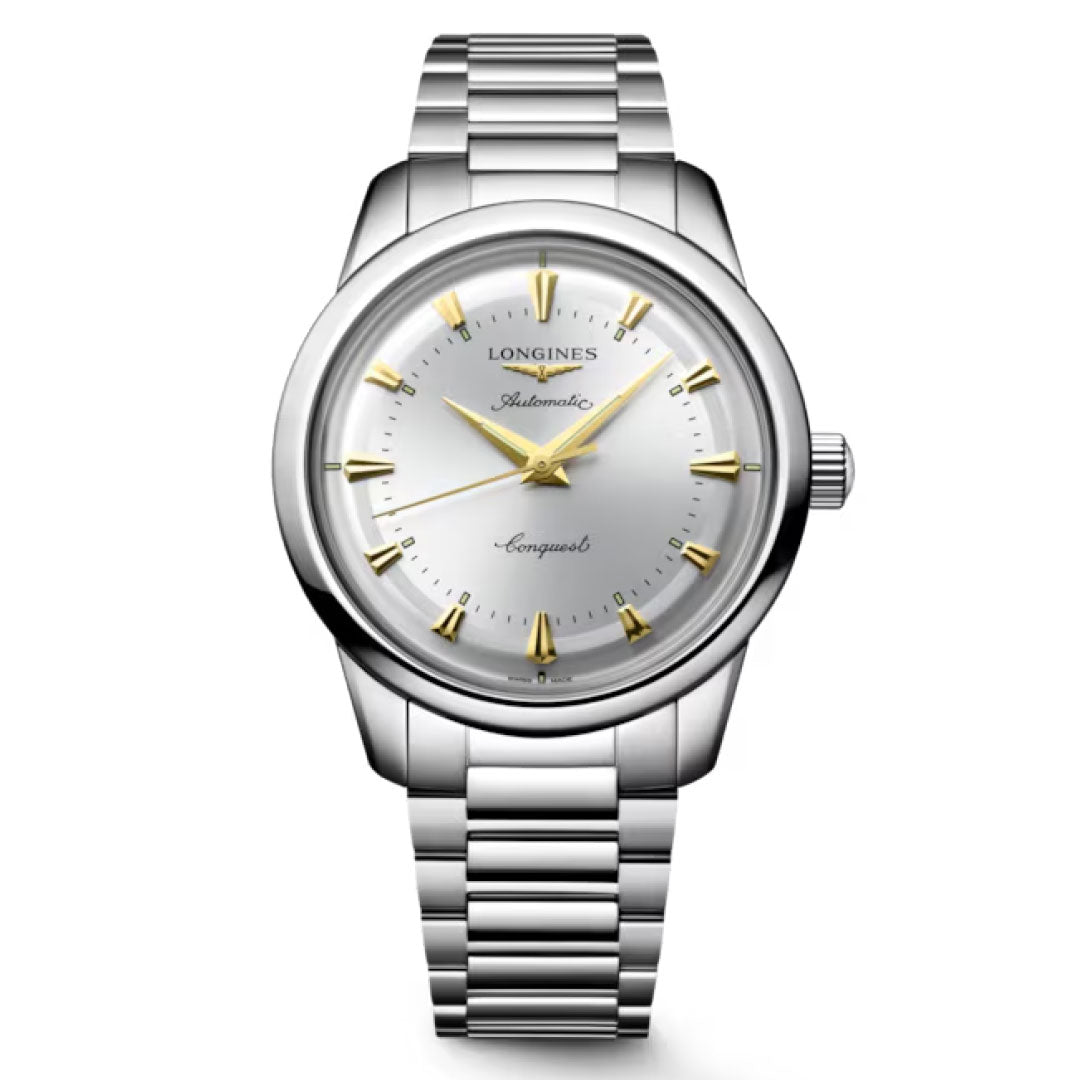The Longines Conquest Heritage Automatic 40mm Watch has a stainless steel case, silver dial, gold markers and hands, metal link band, and displays "Longines Automatic Conquest" on its vintage-inspired face.