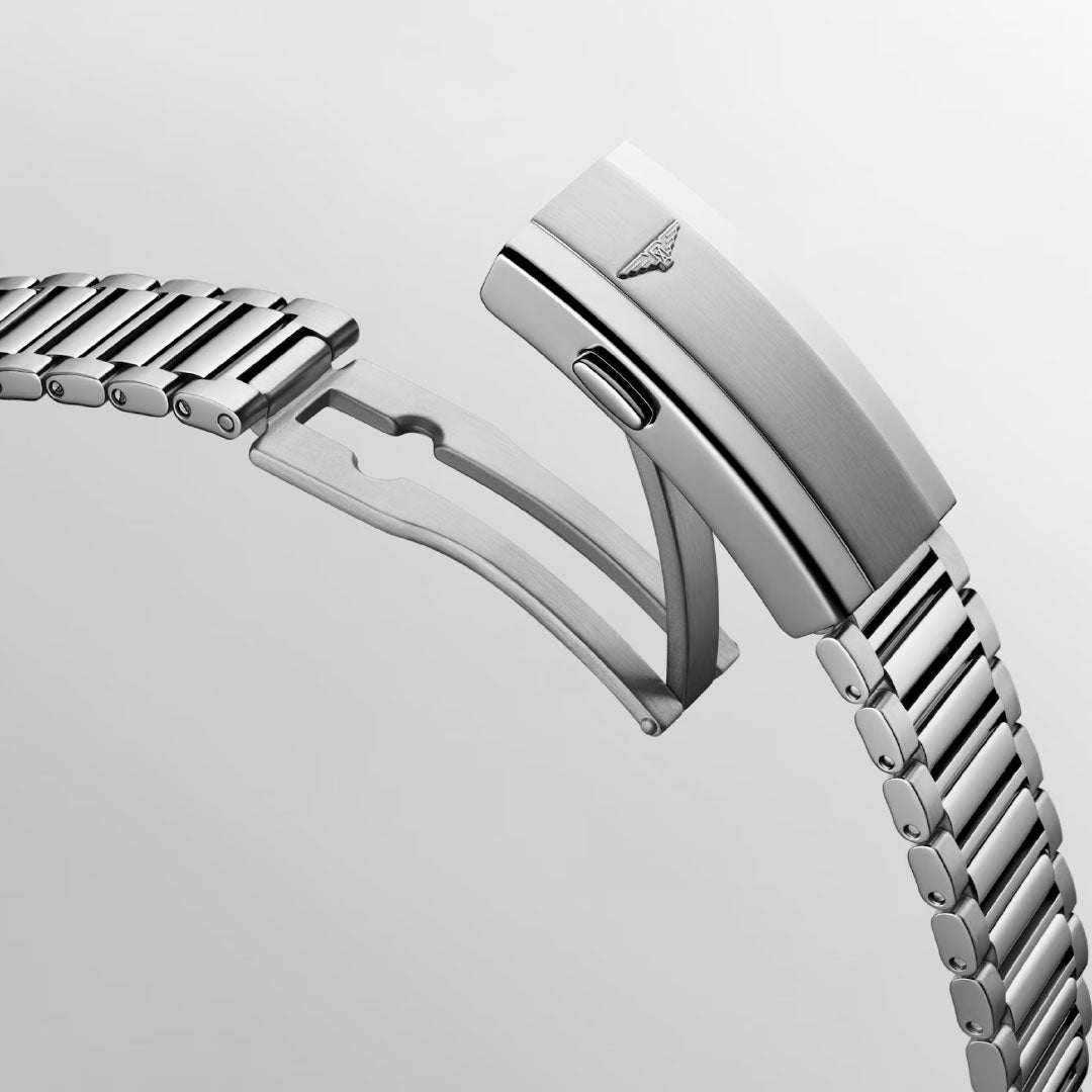 A close-up of the Longines Conquest Heritage Automatic 40mm’s silver metal band with open clasp highlights its hinge mechanism and signature triangular logo, reflecting Longines craftsmanship against a plain light gray background.