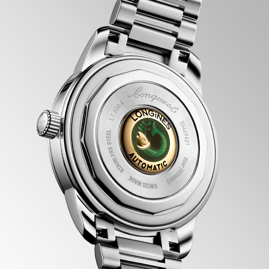 Close-up of the Longines Conquest Heritage Automatic 40mm Watch’s caseback, showcasing vintage-inspired stainless steel, engraved details, a gold-toned center with the Longines logo, and “AUTOMATIC” in black.