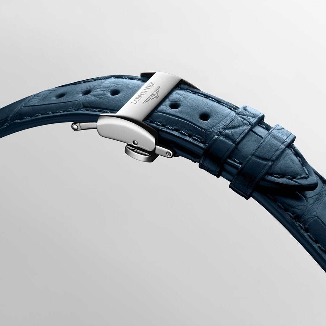 A close-up of a blue leather strap with silver clasp engraved "Longines" highlights the craftsmanship of the Longines Master Collection Automatic Moonphase 40mm Watch, with visible stitching against a plain light gray background.