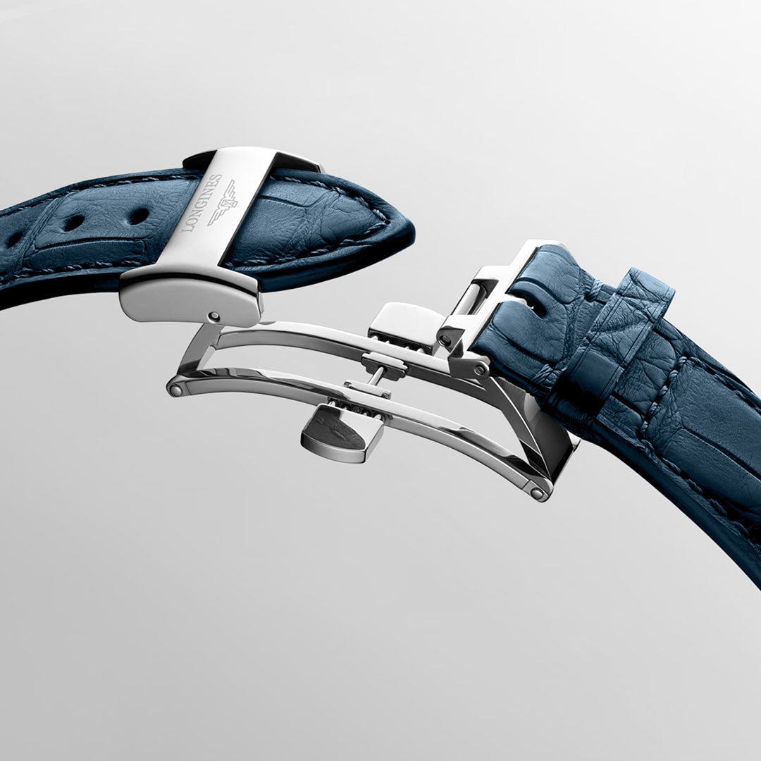 A close-up of the Longines Master Collection Automatic Moonphase 40mm watch's blue leather strap with a silver deployment clasp, displayed open on a light gray background, showcases Longines’ renowned craftsmanship.