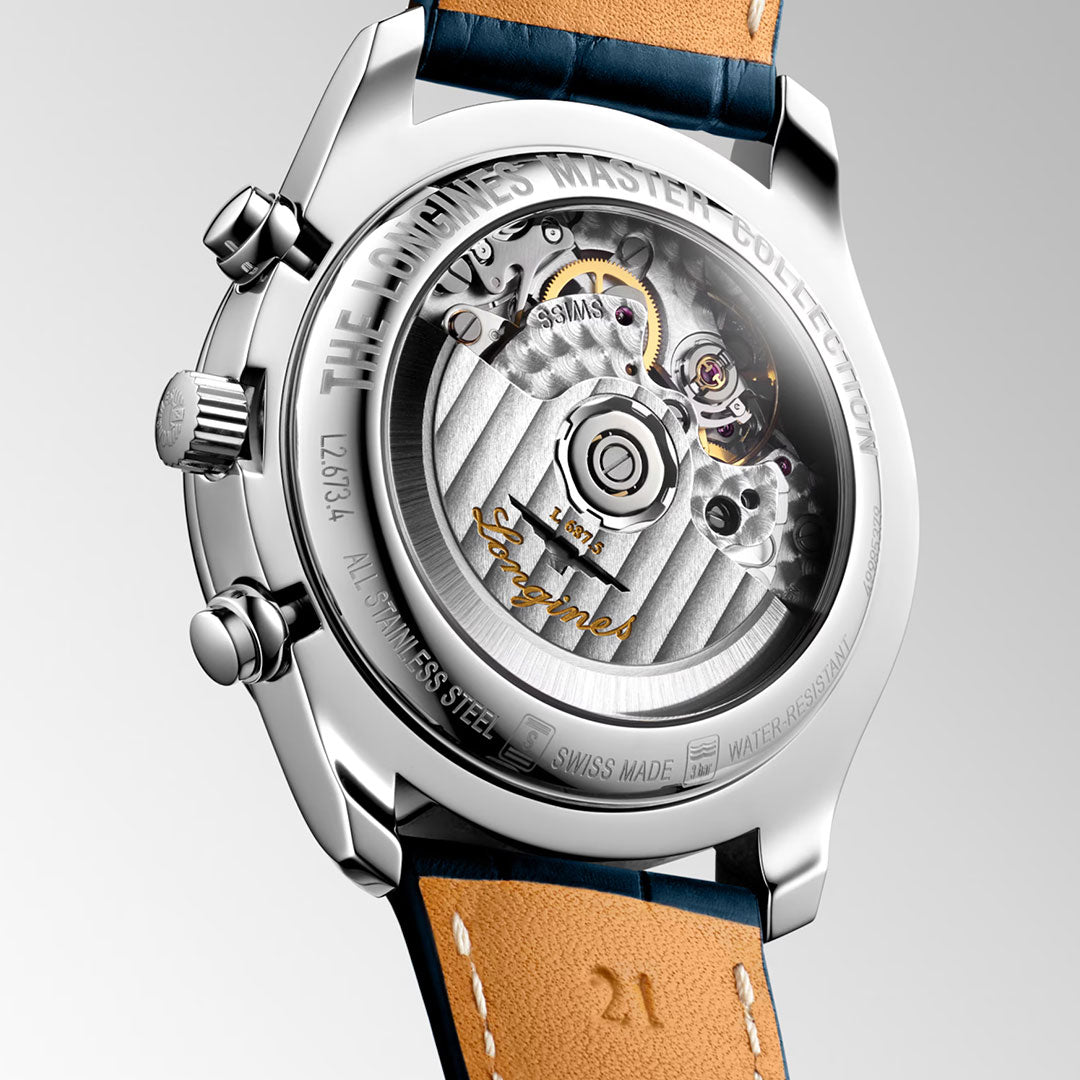 A close-up of the Longines Master Collection Automatic Moonphase 40mm shows its exposed mechanical movement through a transparent caseback, engraved stainless steel details, and a brown leather strap, reflecting Longines' watchmaking expertise.