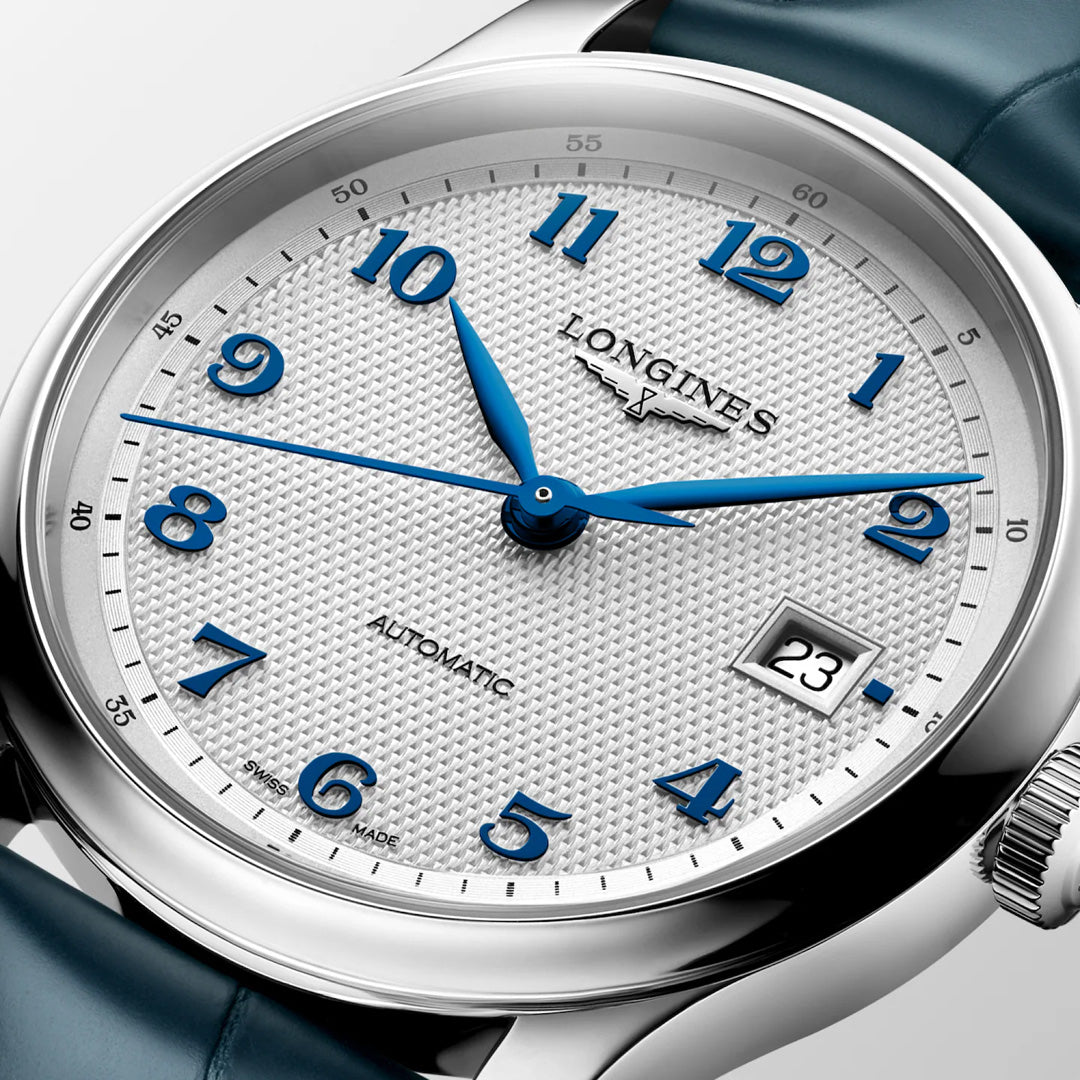 Close-up of the Longines Master Collection Automatic 39mm Watch featuring a textured white dial, blue Arabic numerals and hands, date window at 3 o’clock, and a blue leather strap—a testament to Longines’ renowned craftsmanship.