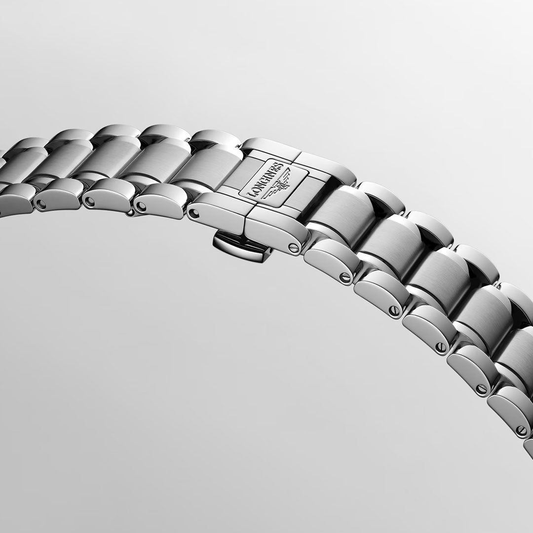 A close-up of the Longines Master Collection Automatic 39mm Watch’s silver metal bracelet, featuring a clasp engraved with “LONGINES,” set against a light grey background, underscores the timeless elegance and expert craftsmanship that define Longines luxury timepieces.