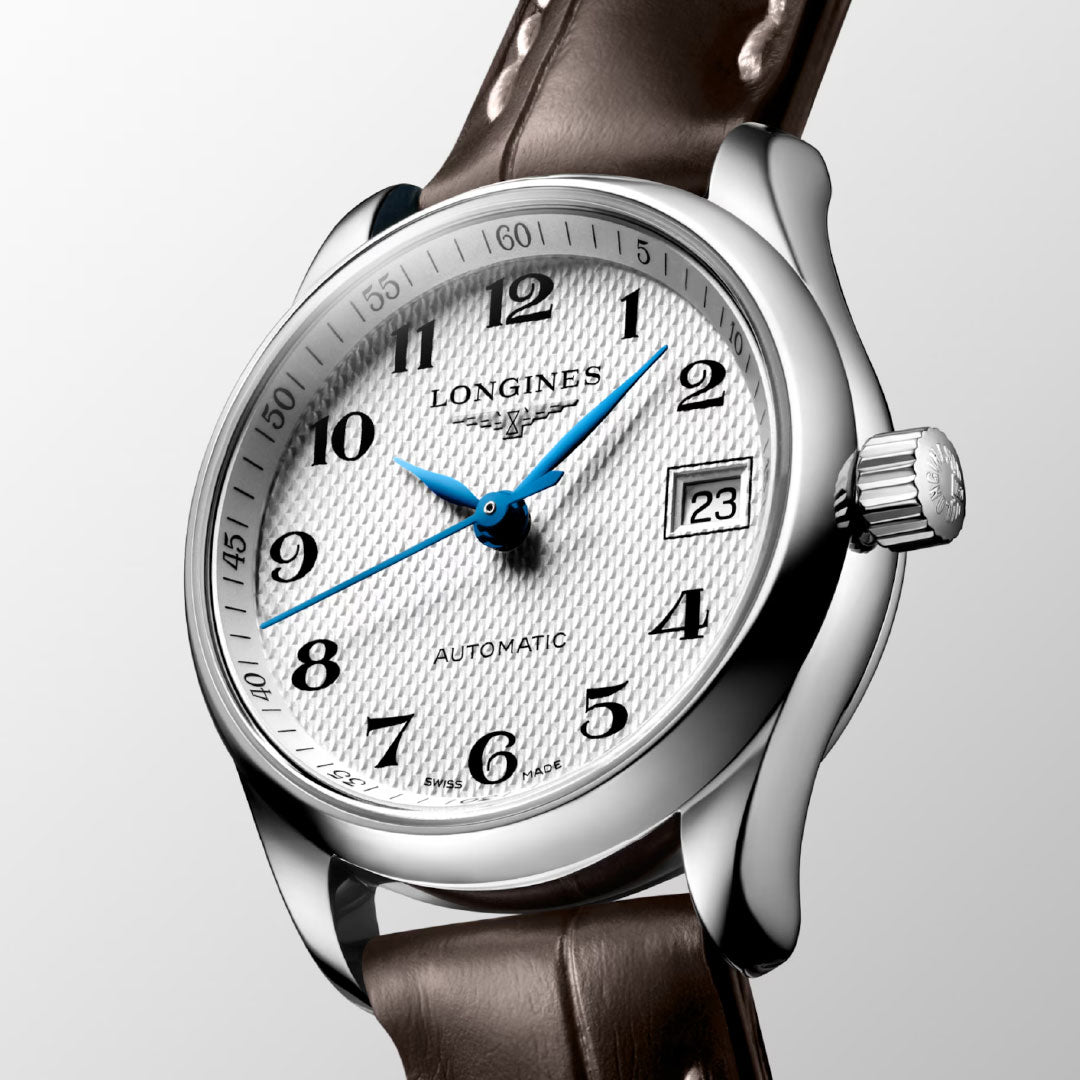 The Longines Master Collection Automatic 25.5mm Watch features a silver case, textured white dial with blue hands, Arabic numerals, date window at “23,” and a brown leather strap—epitomizing Longines craftsmanship.