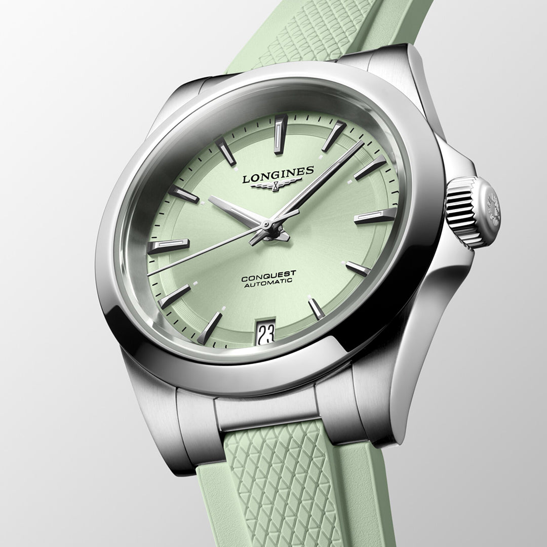 The Longines Conquest Automatic 34mm Watch exemplifies horological excellence with its mint green dial and matching textured strap. Housed in a stainless steel case, it features silver hour markers alongside the "Longines" and "Conquest Automatic" inscriptions. The date is gracefully placed at the 6 o'clock position.