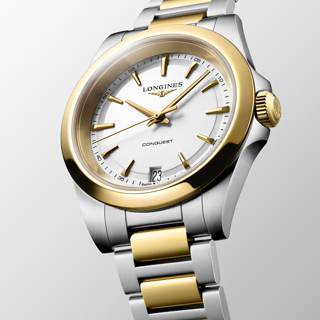 A two-tone silver and gold Longines Conquest Quartz 34mm Watch with a white dial, gold hour markers, and a date window at the 6 o’clock position, exuding sporty elegance.
