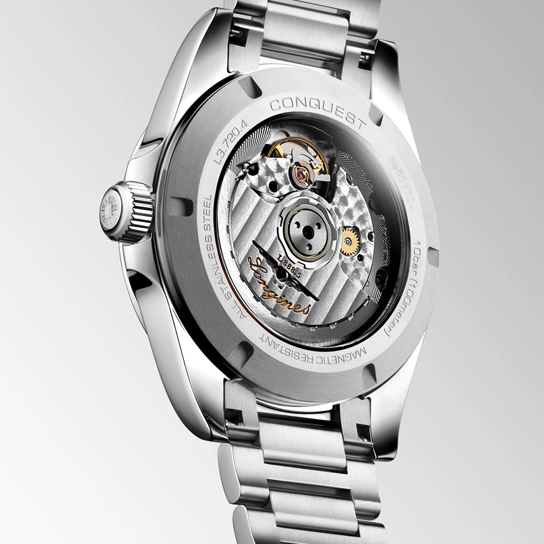 Close-up of the Longines Conquest Automatic 38mm watch, highlighting its self-winding movement through a transparent caseback. "Conquest," "Stainless Steel," and other details are engraved on the back.
