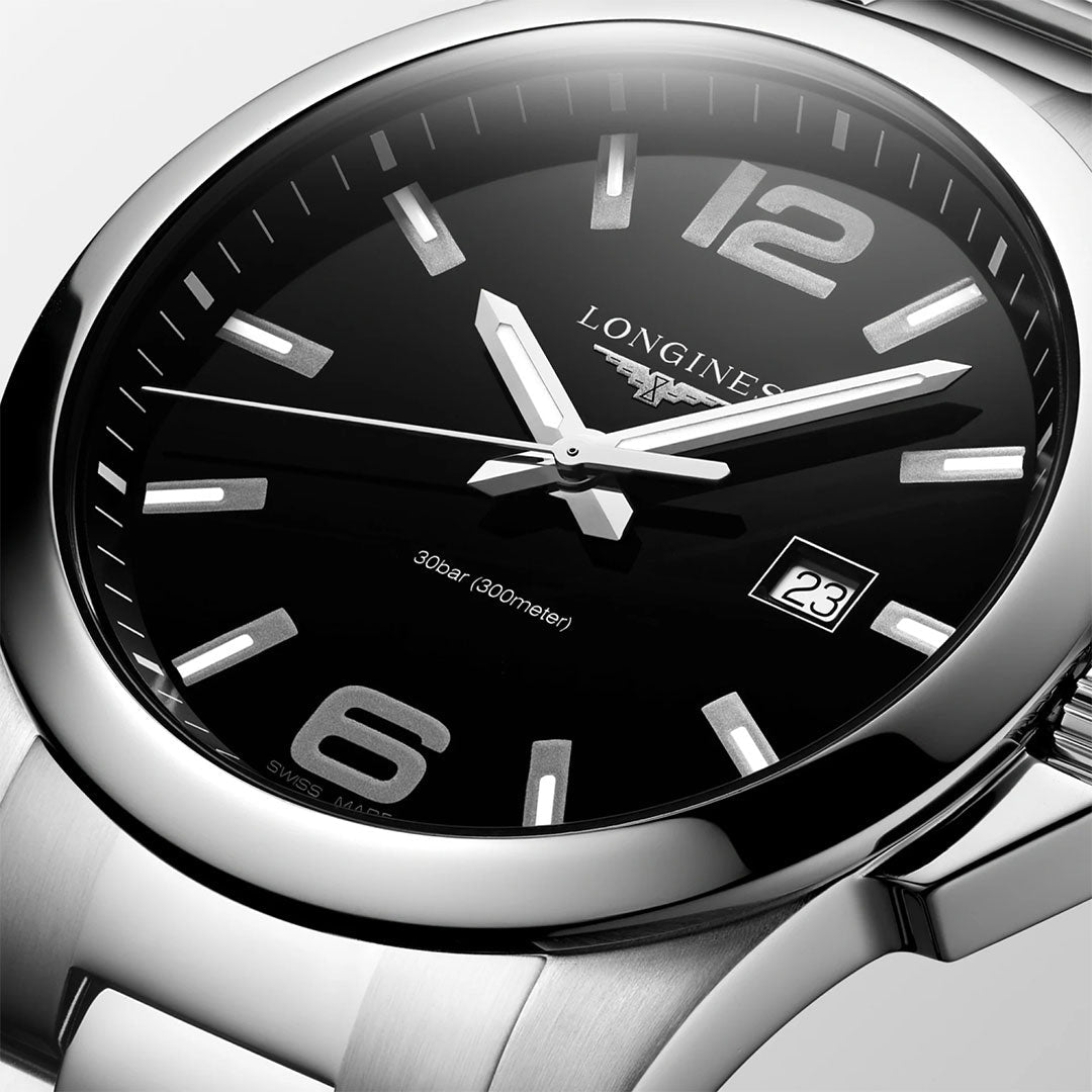 Close-up of the Longines Conquest Quartz 43mm watch, featuring a black dial, silver hour markers, bold numerals at 6 and 12, date window at 3 o’clock, and sleek hands—showcasing Longines’ signature sporty elegance.