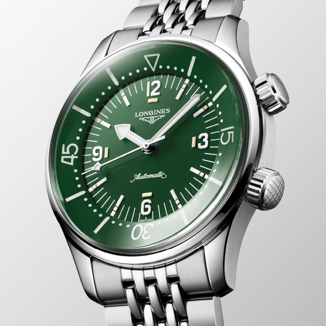 The Longines Legend Diver Automatic 39mm Watch, a stylish timepiece, showcases a green dial accentuated by silver hour markers and minute hand. It features a stainless steel bracelet and includes two side crowns. The watch face prominently displays "Automatic" and "Legend Diver," capturing the timeless allure of prestigious chronometers.