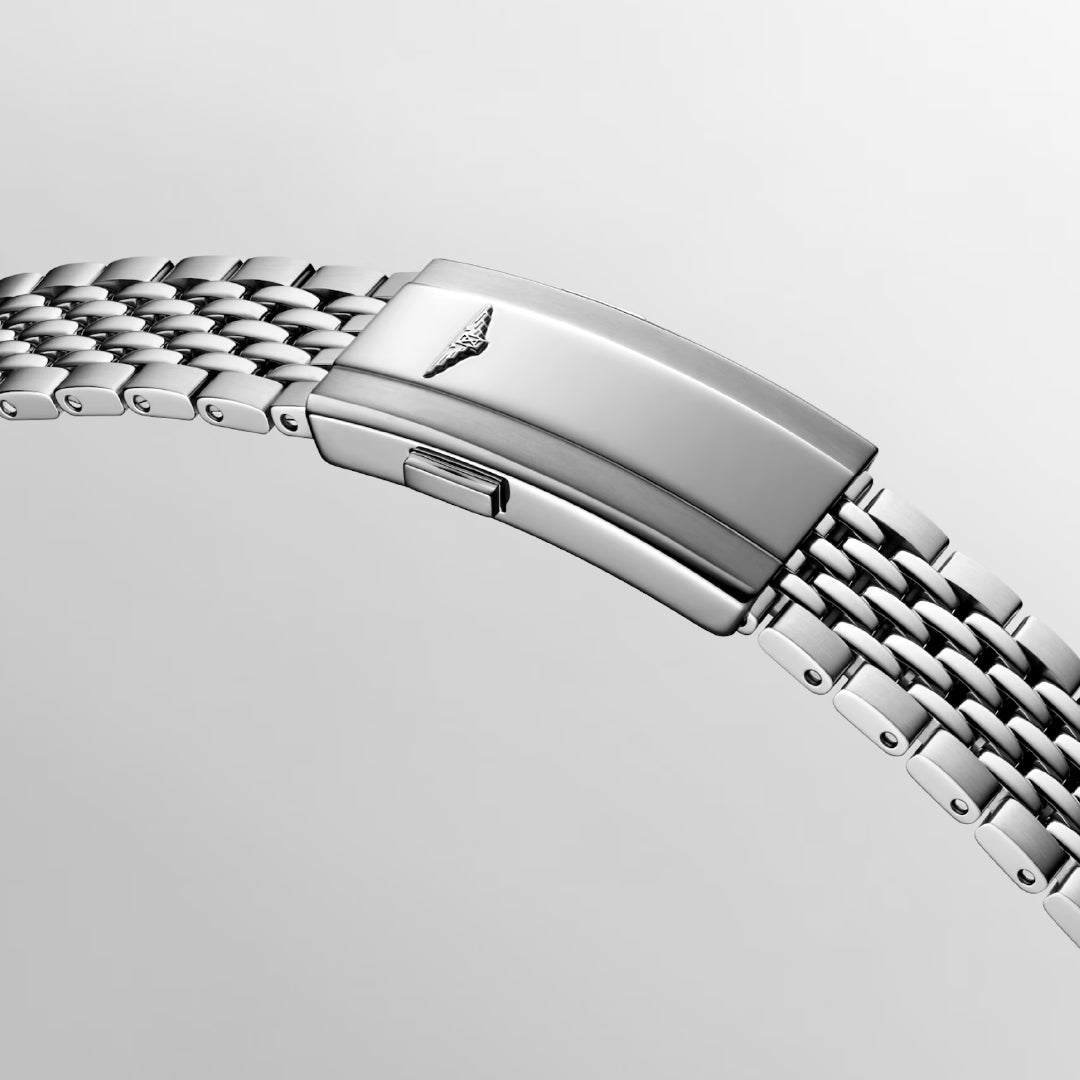 Close-up of a polished silver metal bracelet with interlocking links and a fold-over clasp featuring a small embossed logo. The bracelet mirrors the elegance of the Longines Legend Diver Automatic 39mm Watch, beautifully set against a plain light gray background.