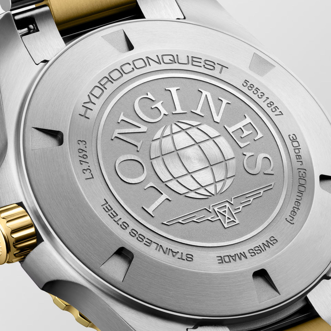 Close-up of the Longines HydroConquest Quartz 42mm Watch case back, highlighting exceptional Swiss craftsmanship with engraved detailing, a globe motif, and the iconic Longines winged hourglass logo in stainless steel complemented by gold accents—a symbol of elegance and enduring quality in luxury sport watches.