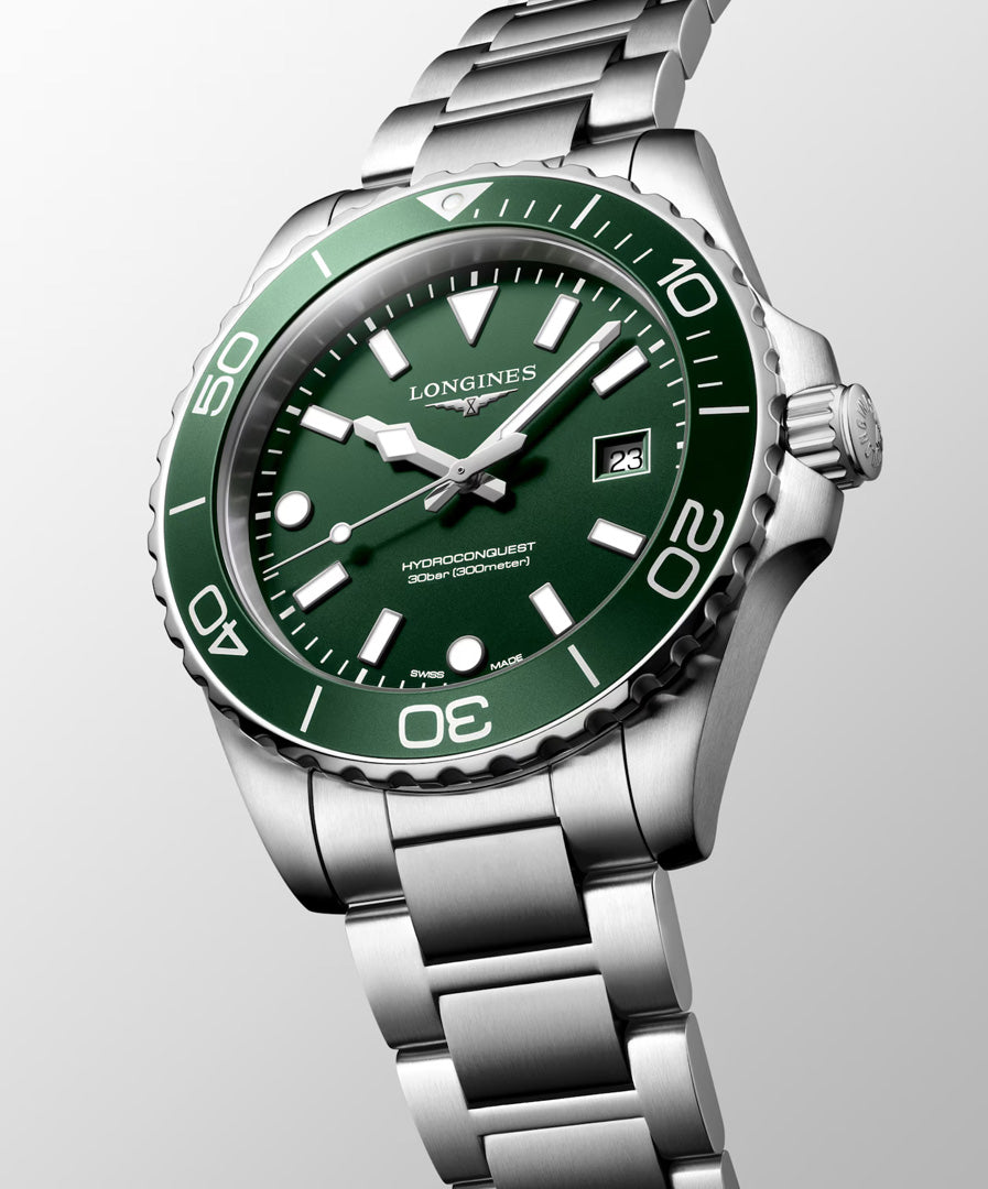 The Longines HydroConquest Quartz 42mm Watch by Longines showcases Swiss watchmaking excellence with its stainless steel design, green bezel and dial, silver hour markers, and a date display at 3 o’clock. Displayed against a light gray background, this timepiece is perfect for sport watch enthusiasts who appreciate both style and precision.