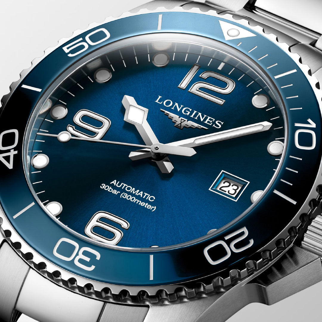 Close-up of the Longines Hydroconquest Automatic 43mm watch featuring a blue dial, silver hour markers, unidirectional bezel, and date display at 3 o'clock. The dial reads "LONGINES AUTOMATIC 30 bar (300 meters).