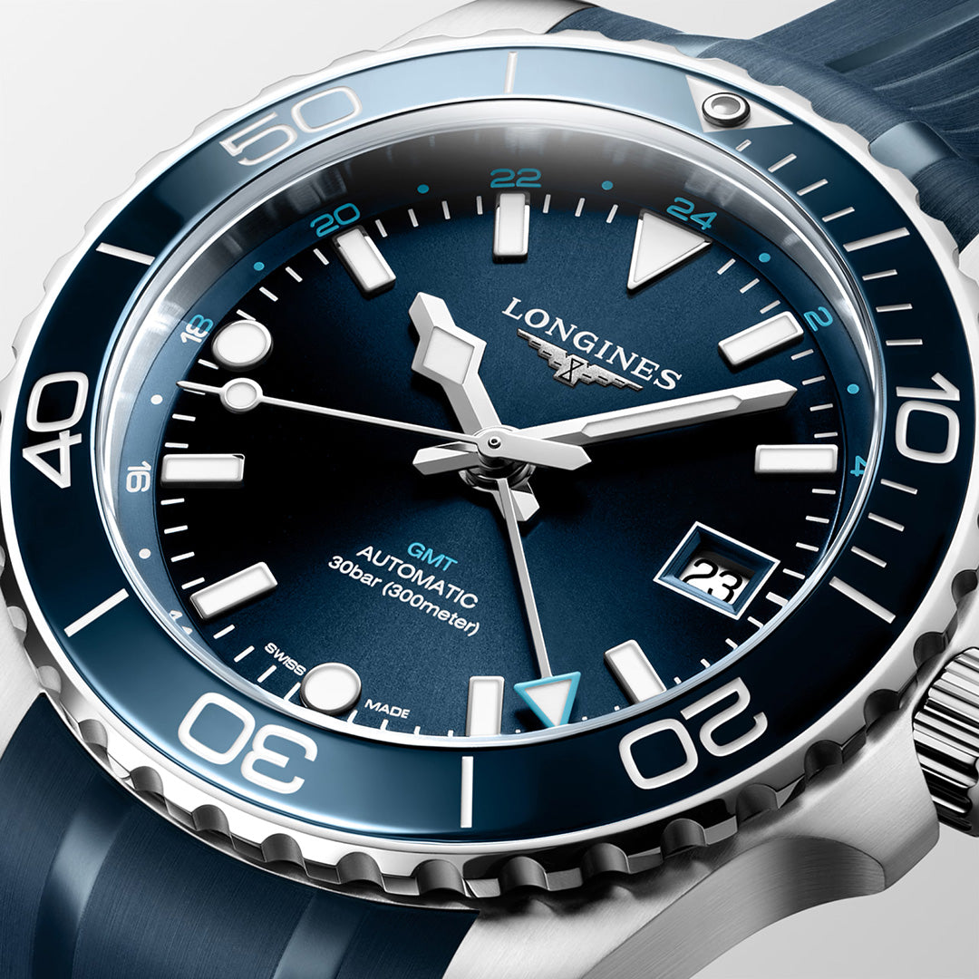Close-up of a Longines HydroConquest GMT Automatic 41mm watch by Longines, part of the Longines Sport Collection. This timepiece features a blue dial with Swiss Super-LumiNova-coated silver hour markers and hands, a date window, and a blue rotating bezel. The watch displays the time as 10:10 and is water-resistant to 300 meters.