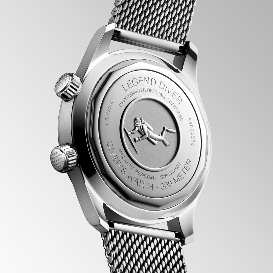 The Longines Legend Diver 59 Automatic 42mm Watch features an engraved diver and "Legend Diver" text on the back, is water-resistant to 300m, includes a mesh strap, Swiss Super-Luminova accents, and two crowns on its stainless steel case.