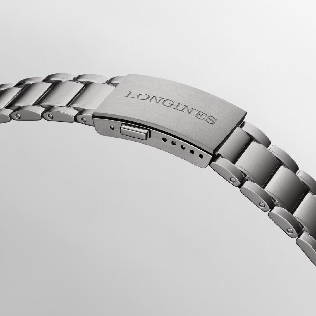 Close-up of a titanium watch band with a clasp engraved "LONGINES." This sophisticated Longines Spirit Zulu Time Titanium Case and Titanium Automatic 39mm Watch is designed with links and an adjustable clasp with multiple holes, offering classic style and advanced functionality perfect for dual time zone tracking.