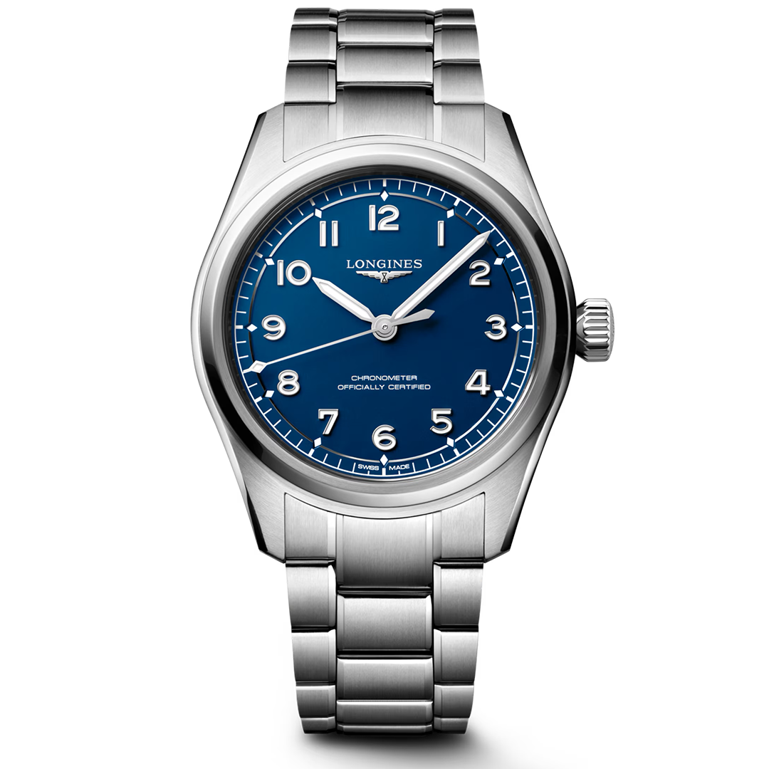 The Longines Spirit Pilot Automatic 39mm Watch is a silver stainless steel wristwatch featuring a blue dial with white Arabic numerals and three hands. The brand name “Longines” appears below the 12 o’clock position. Inspired by classic aviator timepieces, this model showcases a metal bracelet and polished bezel, offering precision and reliability that reflect its chronometer certification.