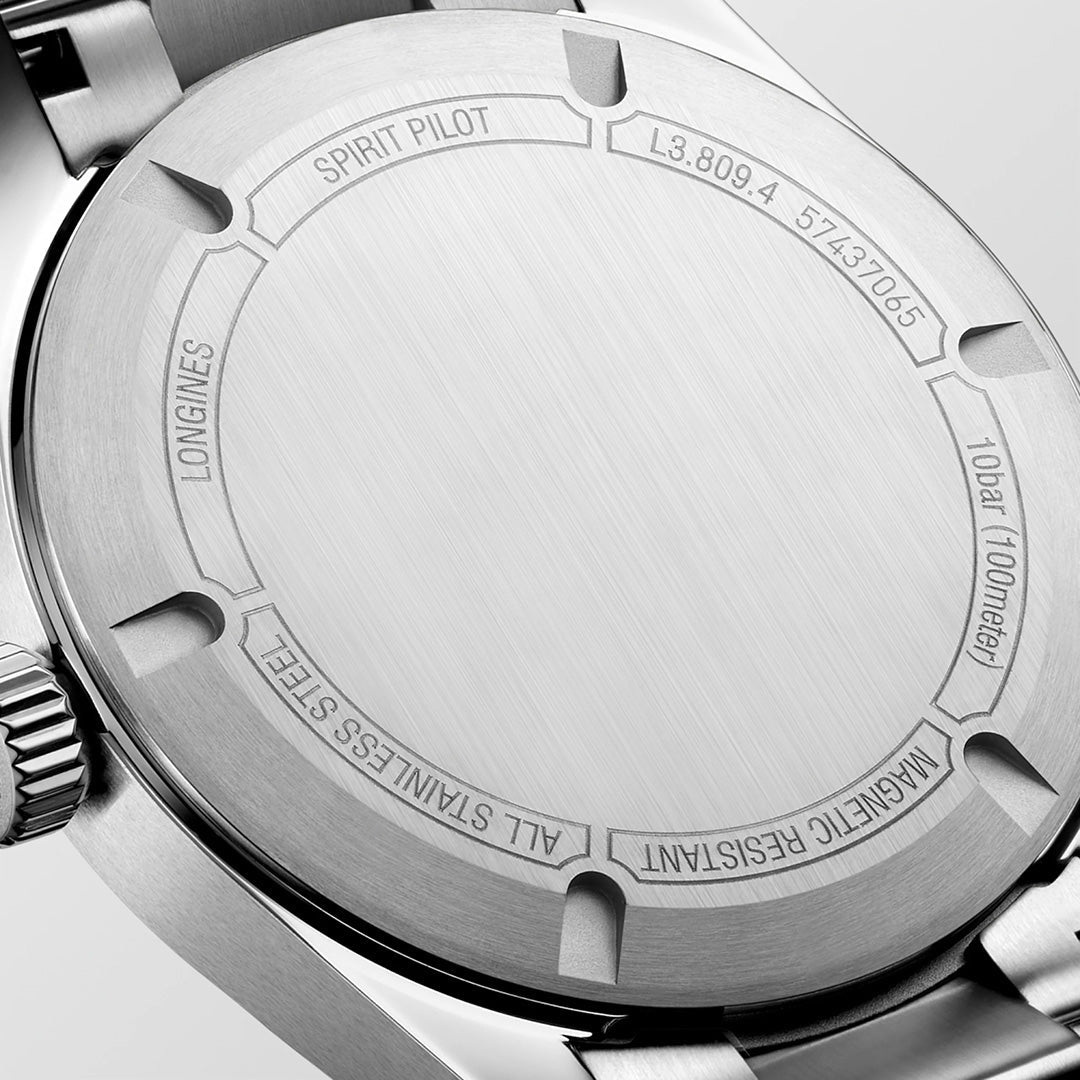 Close-up of the stainless steel case back of the Longines Spirit Pilot Automatic 39mm Watch, engraved with “SPIRIT PILOT,” “10 bar (100 meters),” “ALL STAINLESS STEEL,” and serial numbers. The brushed metal texture is clearly visible, showcasing the expert craftsmanship of this Longines timepiece.