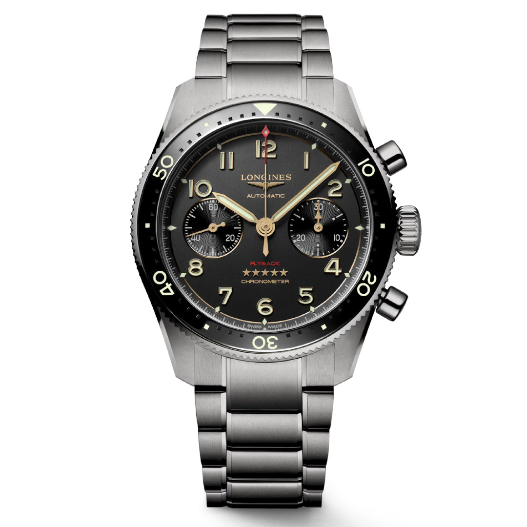 The Longines Spirit Flyback Titanium Automatic 42mm Watch blends aviators' spirit with elegance, featuring a stainless steel bracelet, a black dial with gold numerals, three subdials, and a red-tipped hand at 12 o'clock. This chronometer-certified piece has a minimalist black bezel with luminous markers.