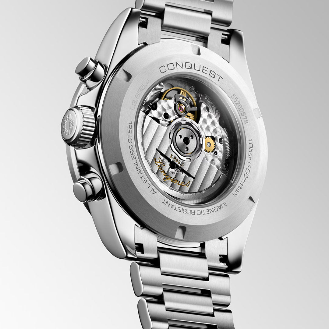 Close-up of the back of the Longines Conquest Chronograph Automatic 42mm Watch, revealing its intricate mechanical movement through a transparent case and engraved details, with "Longines" branding.