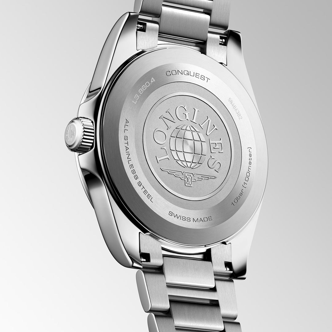 Close-up of the back of a stainless steel Longines Conquest Quartz 41mm watch by renowned Swiss watchmaker Longines, highlighting engraved branding, a globe motif, detailed specifications, and a polished bracelet against a neutral gradient background.